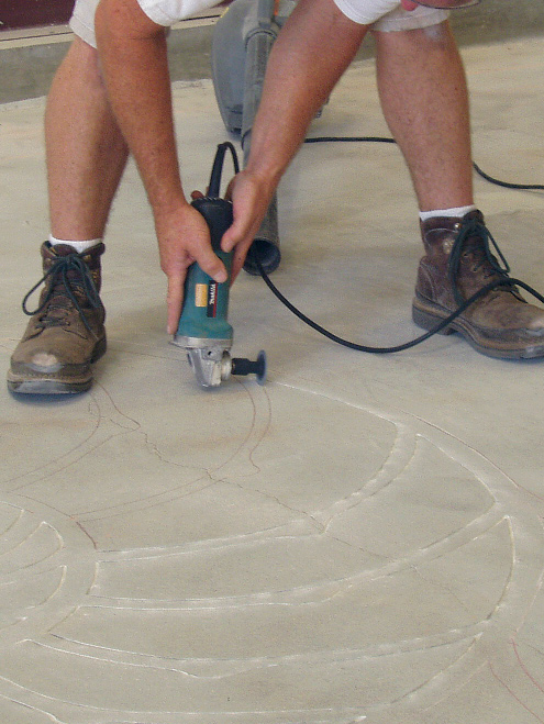 Bob Harris using a grinder to engrave a concrete floor with a 2 inch blade.
