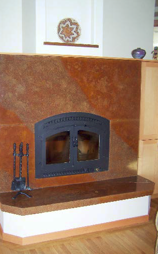 Concrete fireplace and hearth in orange and browns.