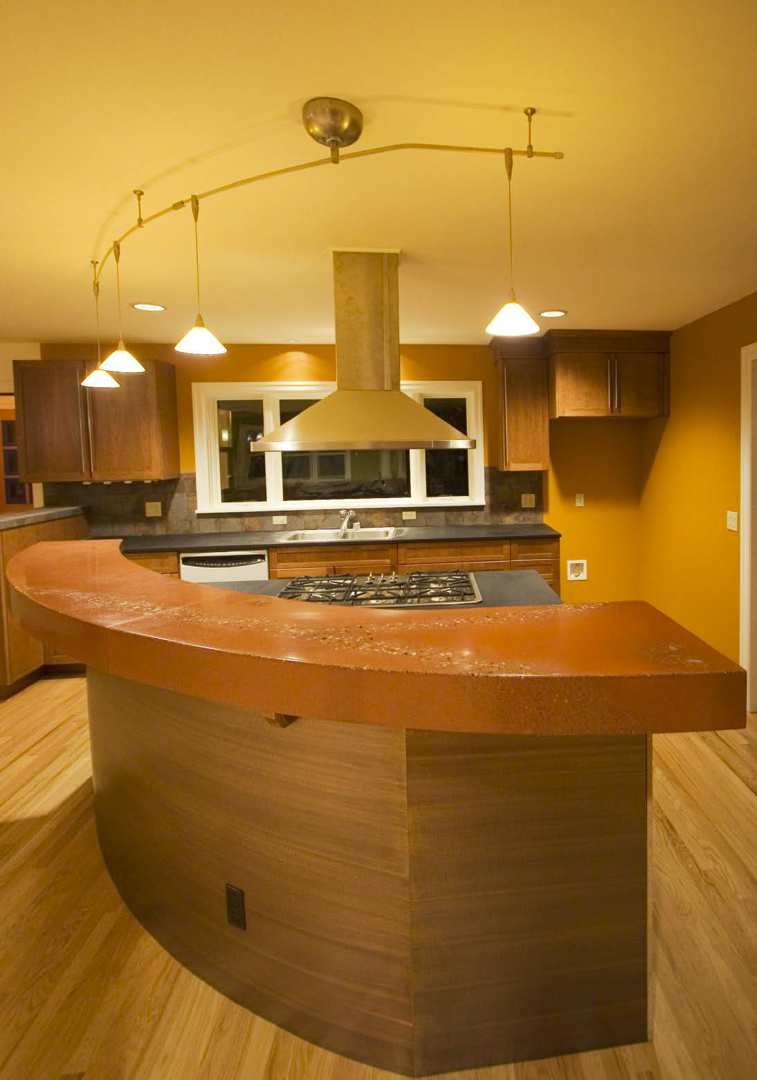 Orange concrete countertop creates a warm kitchen bar.