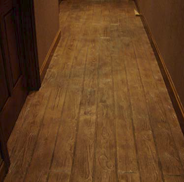 With the range of products available today, artisans in the decorative and faux markets have almost unlimited design capabilities. Here a faux wood plank look down the hallway accomplished stain.