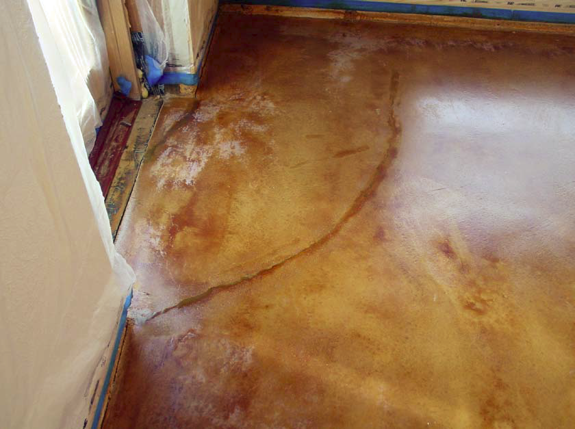 Water that condensed on a stained concrete floor by a cold doorway caused the sealer to white out in the spots where the water pooled.
