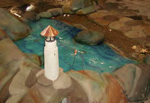 A depiction of a lighthouse near a concrete fountain.