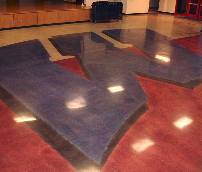 A school logo is placed on the floor with colors and polished concrete.