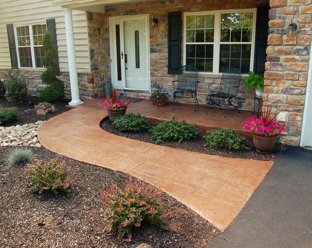 A stained and stamped concrete pathway leading to a front door.