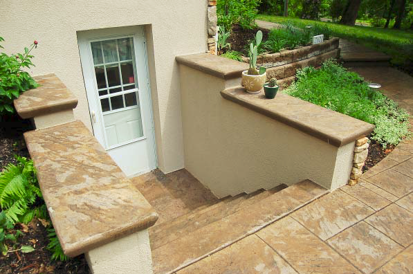Steps down to a basement outdoors that have been refinished with stamped concrete.