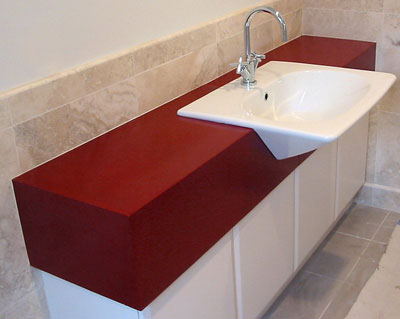 Brilliant deep red bathroom concrete countertop with an ADA approved white sink.