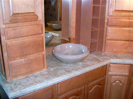 Bathroom concrete countertop in a mottled tan and a vessel sink.