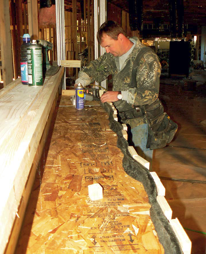 Winkler carefully pins a FossilCrete form to give this countertop a natural-looking edge.