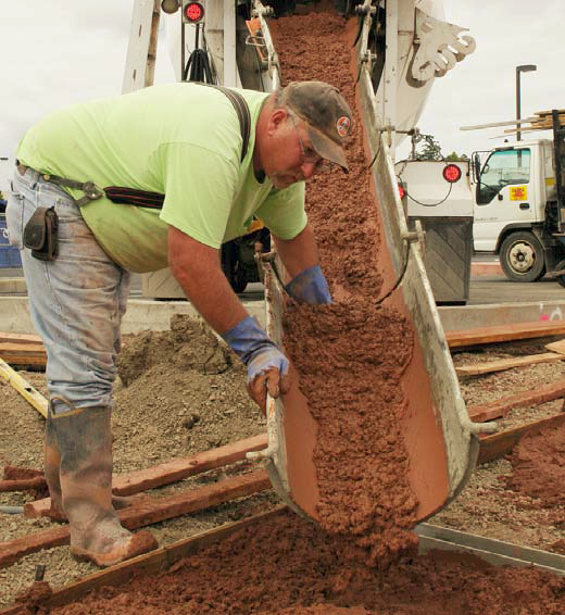 An employee of Delta Sand & Gravel Corp., based in Eugene, Ore. pours integrally colored concrete onto a jobsite.