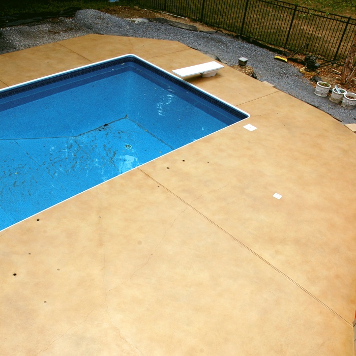 A stained concrete pool deck in a light tan color