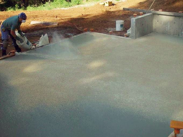 A contractor installs Marblecrete on a concrete slab.