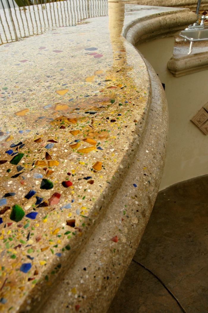 A concrete countertop edge that has been formed in a curve and inayed with glass aggregate.