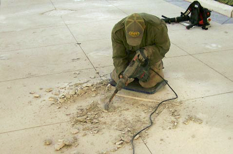 Using a vibrating hammer to break up old concrete.