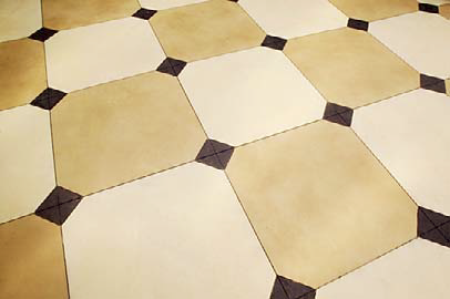 Checkerboard concrete tiles with alternating colors of yellow and white with brown inserts.