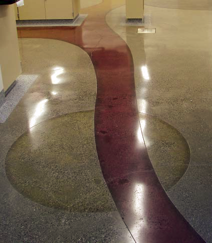 A circle and a ribbon in red and yellow are embedded into this concrete floor with dyes and polished for high gloss effect.