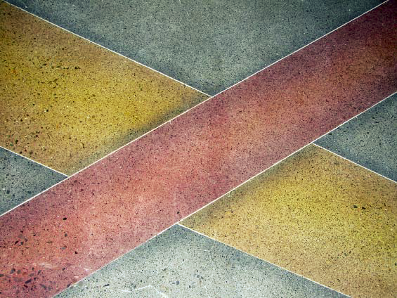 Using dyes on polished concrete these yellow and red ribbons intersect on each other on this concrete floor.