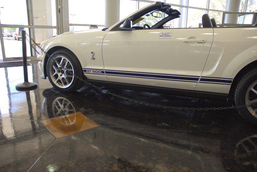 A white GT 500 is parked on a floor that has been coated with metallic epoxy.