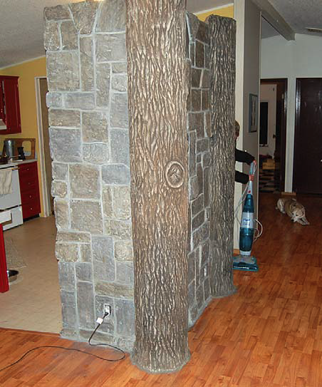 Indoor carved concrete log beam with carved concrete rock surround.
