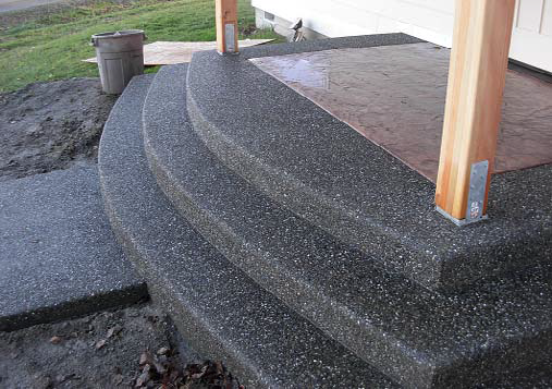 Exposed aggregate steps with stained concrete inlay under cover.