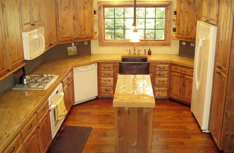 A large kitchen with concrete countertops in light brown and tan colors.