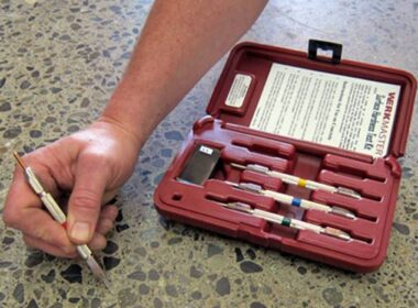 A hand next to a mohs testing kit