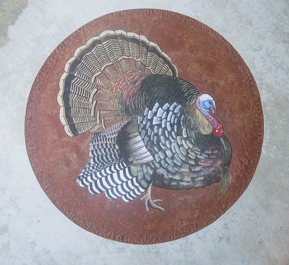 Turkey art installed on a concrete patio using stains and engraving techniques.