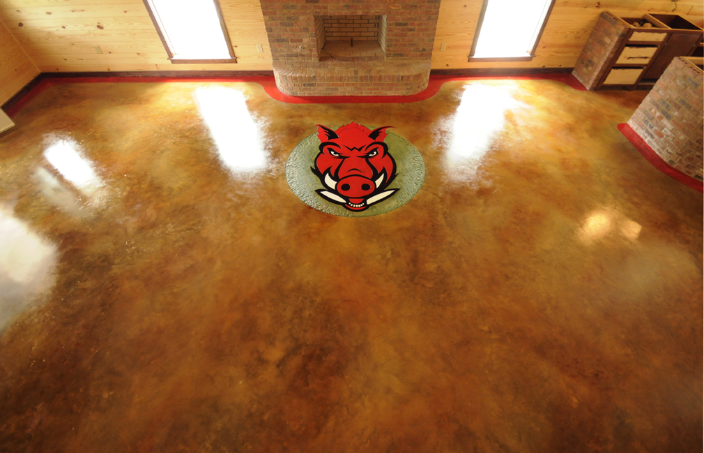 An indoor space that has the Arkansas Razorback Logo installed on the concrete