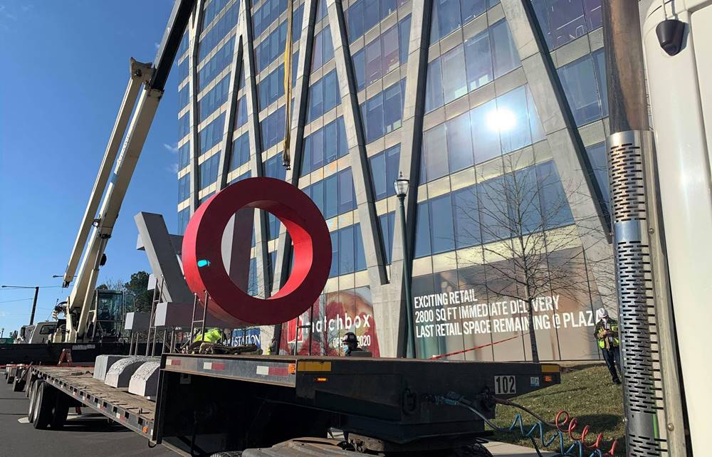 A crane moves the O in the LOVE concrete sculpture into place