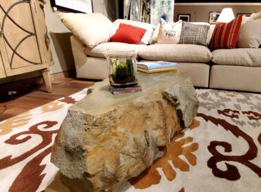 Carved concrete coffee table on a mutli-colored area rug.