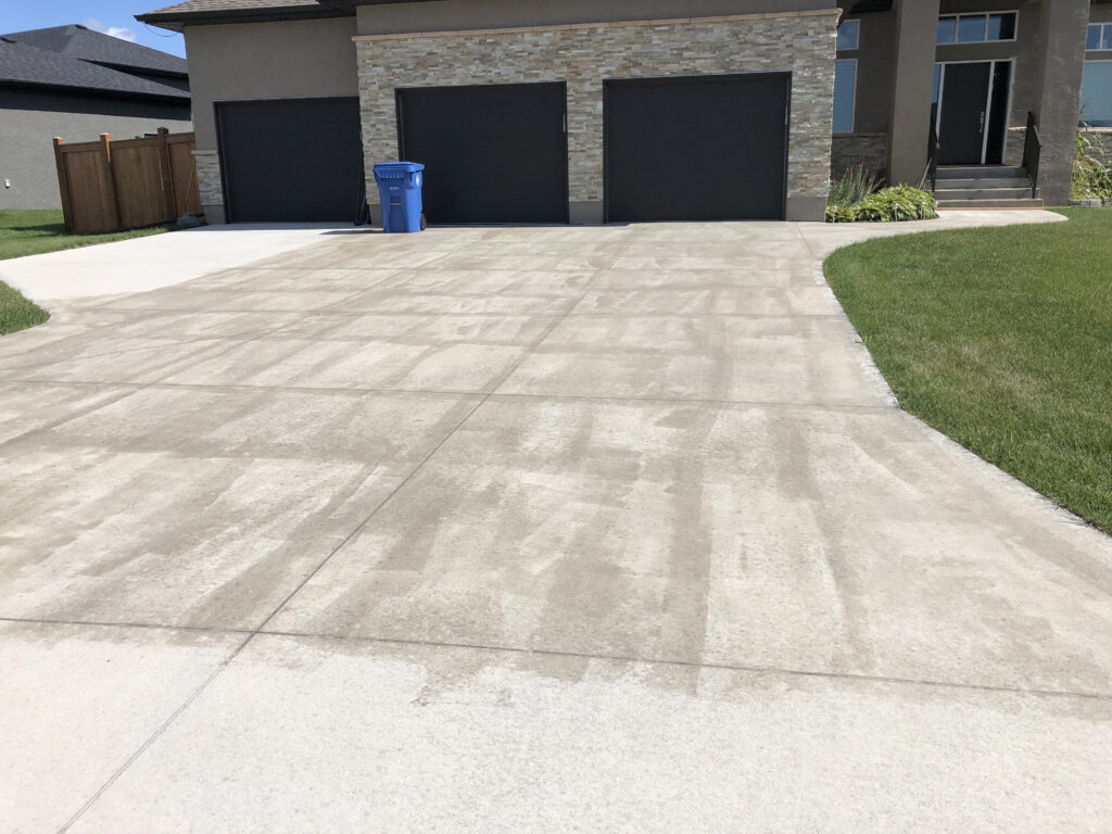 A blotchy concrete driveway where sealers have failed.