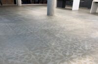 As part of an office renovation in downtown Chicago, the existing concrete floor was grinded, stenciled, stained and sealed. Part of the process involved manipulating the intensity of the stain and erasing parts of the stencil to create a worn look