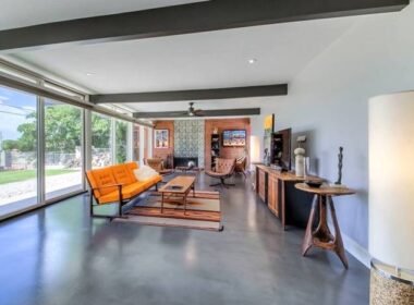 A home with gray concrete floors and an orange couch