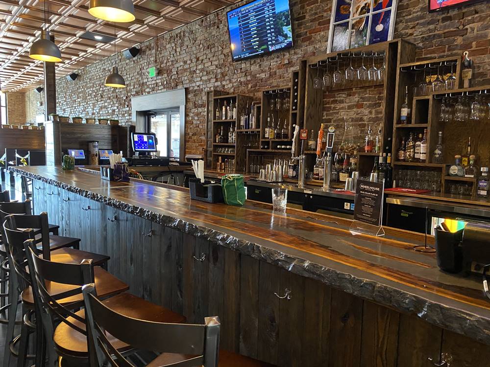 concrete countertops were used in a bar with a live edge feel