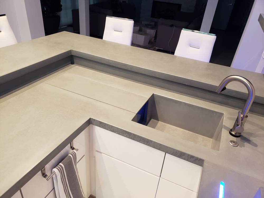 this concrete countertop is in a residential bar and it features a hidden champagne trough