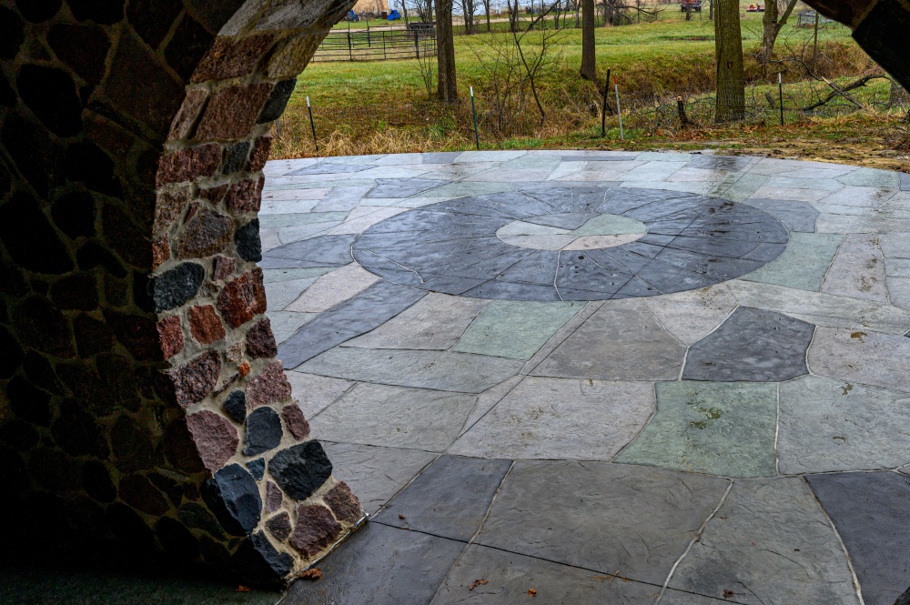 a look at a concrete patio from a "hobbit" like covered porch