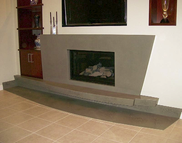 Mike Wellman of Concast Studios worked with the client on the design of this fireplace, which matches the art deco style of the house. It has what he calls flowing rivers of decorative stone and shell.