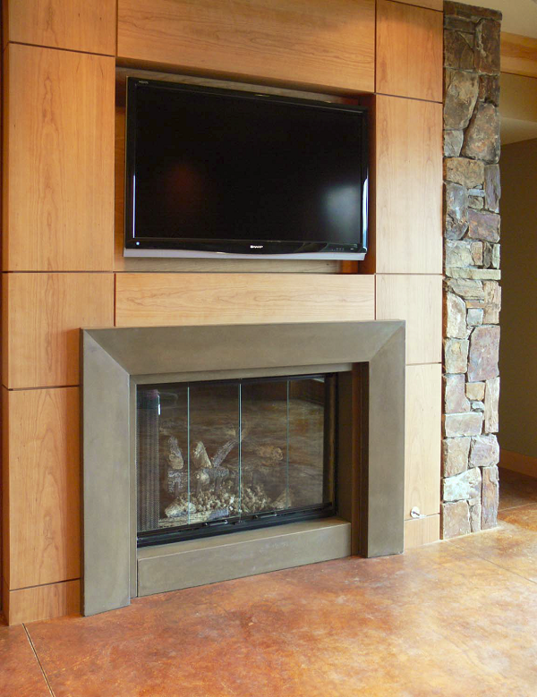 This single-piece GFRC fireplace from Absolute ConcreteWorks LLC was surround-cast in a solid color. The face tapers slightly towards the firebox. The block hearth is a separate piece.