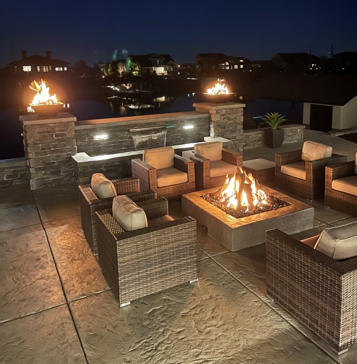Concrete patio with fire feature at night