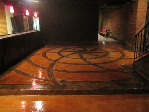 A web of dark circles engraved and stained on to the concrete floor with lighter colored background to make the web pop.