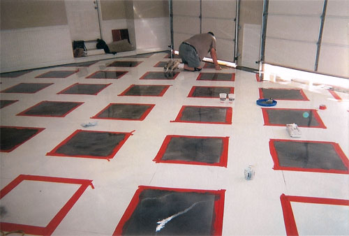 Planning out the red and gray squares on the concrete floor.