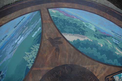 A mural on top of a mountaintop that shows the hikers where to look for specific landmarks.