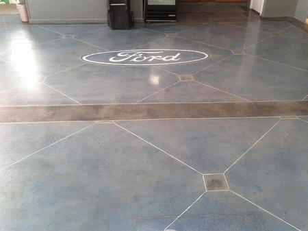 Ford logo glows on an engraved concrete blue stained concrete floor
