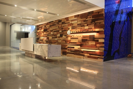 three colors of wood on a wall contrast with the polished concrete floors