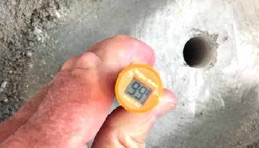 Measuring the moisture in the concrete with a yellow meter.