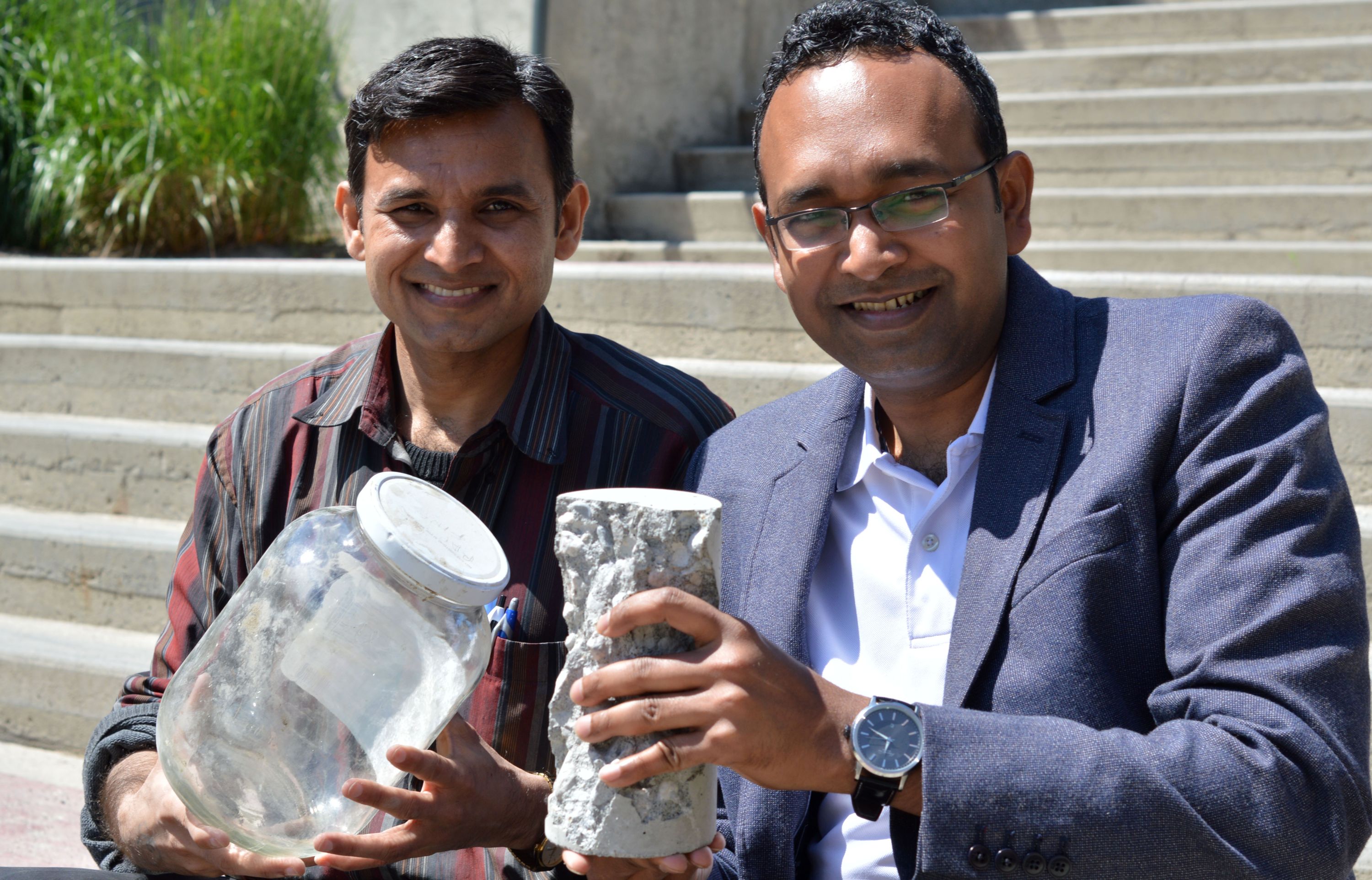 UBC's Anant Parghi (left) and Shahria Alam hold up a piece of 'green' concrete and some of the glass that helped make it. 