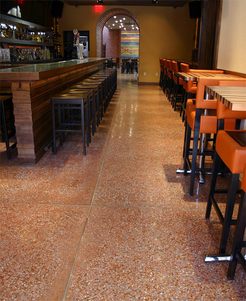 Polished concrete floor and a concrete countertop make this bar pop.