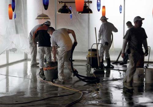The crew at Concrete-Technology Modesto remove glue residue and wash the concrete surface before applying Quick Dye from Concrete Coatings Inc.