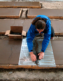 Project designer Kelley Burnham seeds crushed amber glass, aided by plasma-cut steel templates.