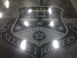 Allied Fighters logo within a polished concrete floors using dyes. Dyes are used in polished concrete not stains.