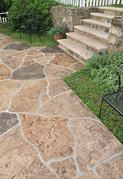 Natural stone look achieved with stamped concrete and neutral colored stains.